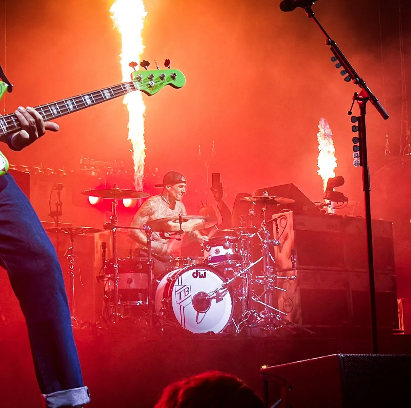 Travis Barker behind the kit between pillars of pyro
